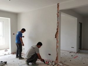 عمال يقومون بهدم جزئي لجدران داخلية في منزل بالكويت