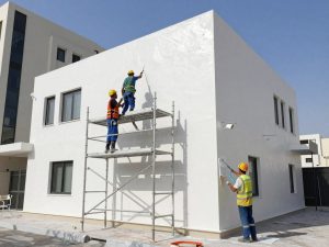 فريق عمل صباغين محترفين يعملون على واجهة مبنى في المنطقة العاشرة